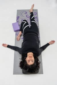 woman lying down in half saddle yoga pose